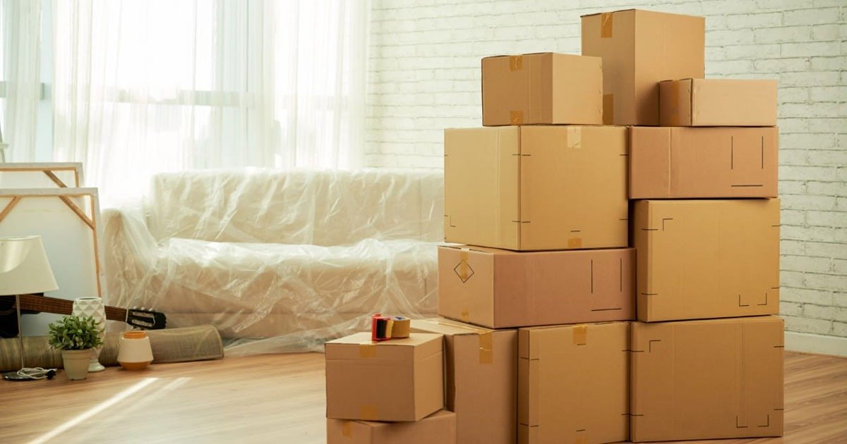A stack of cardboard boxes in a living room, ready for packing and moving to a new location.