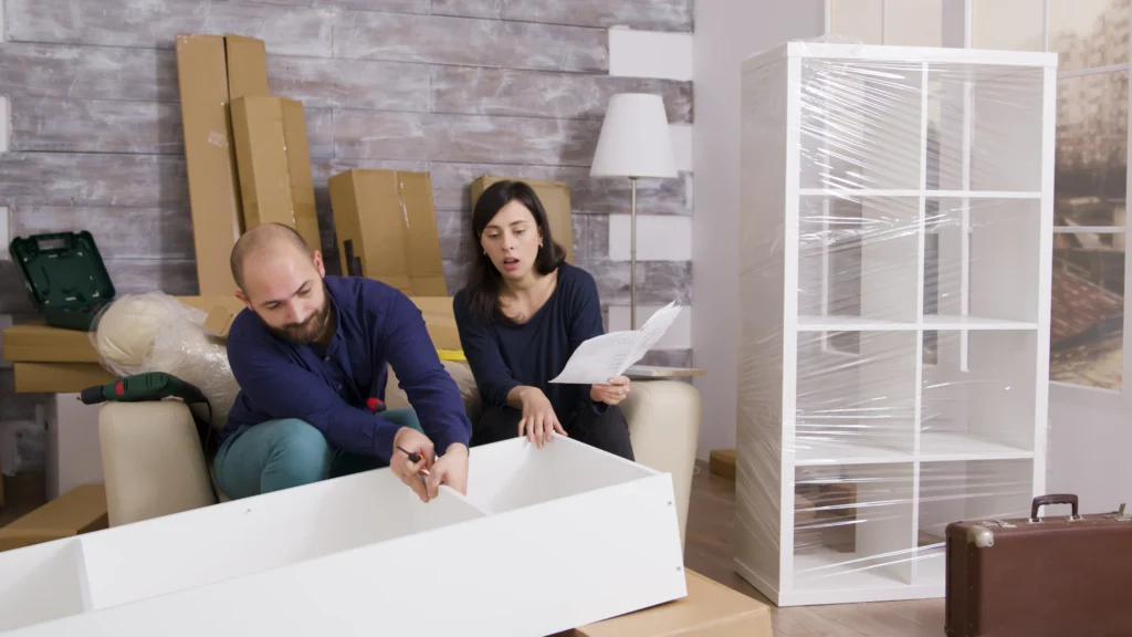 A cluttered room filled with various boxes and pieces of furniture scattered throughout the space.