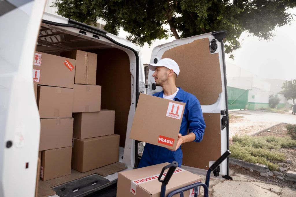 A man is seen placing boxes into the back of a truck for loading.