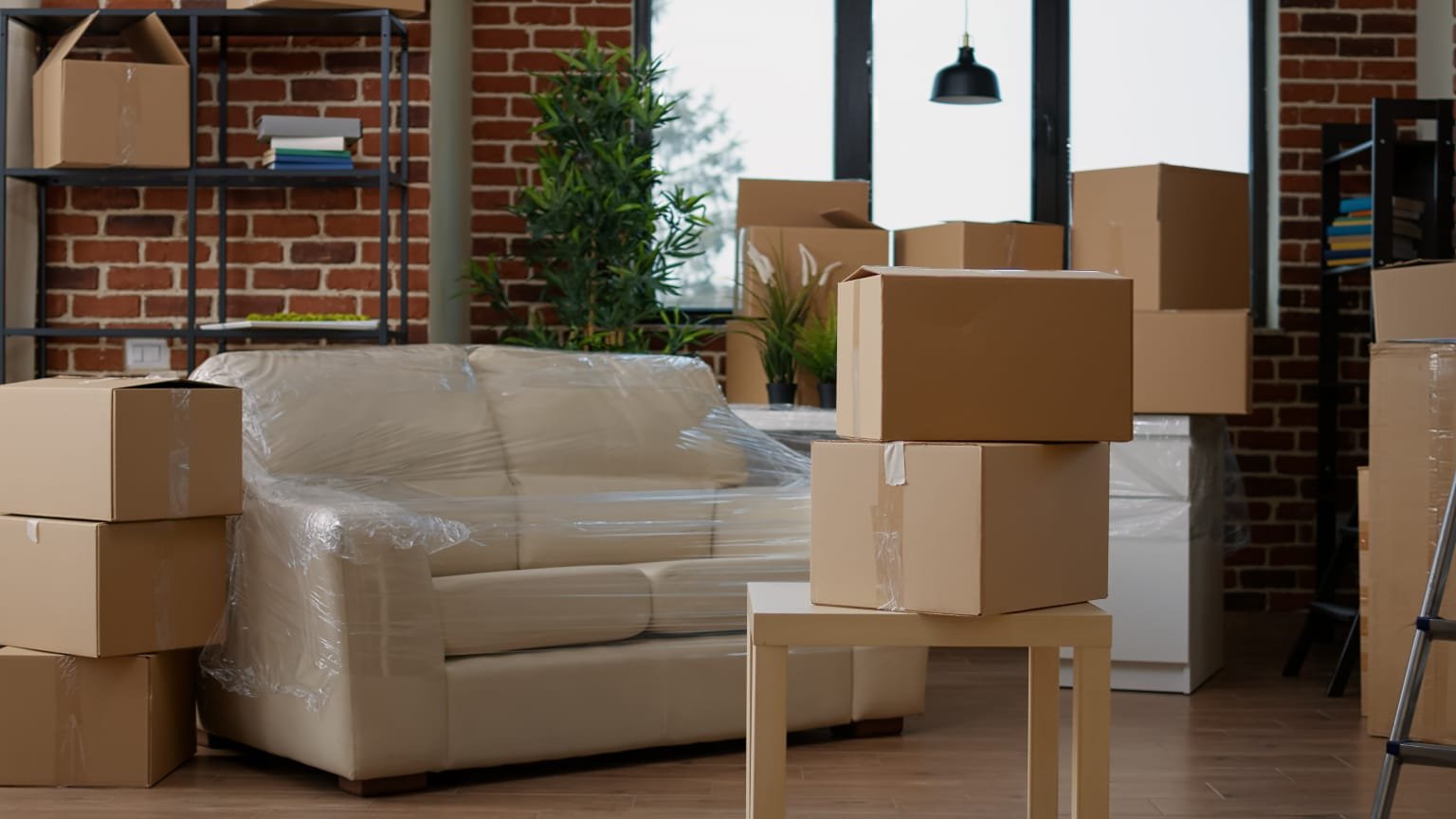 A cluttered room filled with various boxes and pieces of furniture scattered throughout the space.