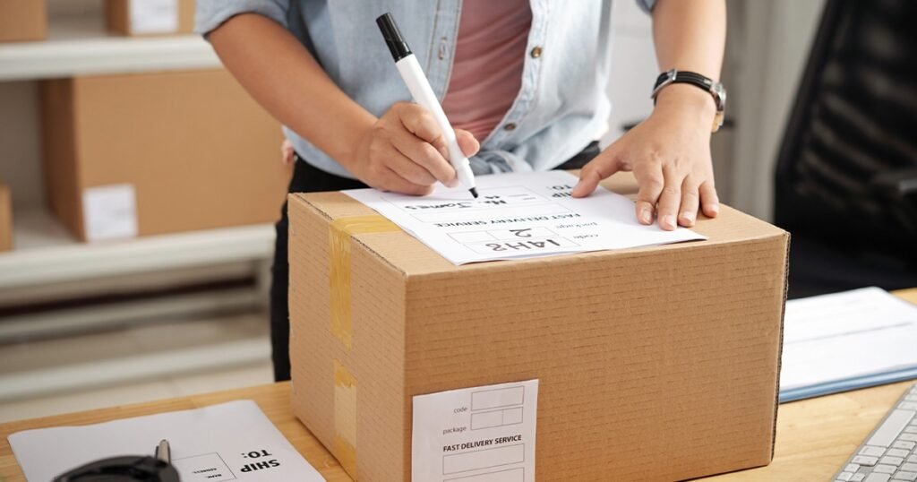 A woman writes on paper with a pen, emphasizing the importance of creating a packing timeline early.